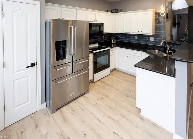 kitchen featuring kitchen peninsula, high end refrigerator, sink, white range with electric cooktop, and white cabinetry