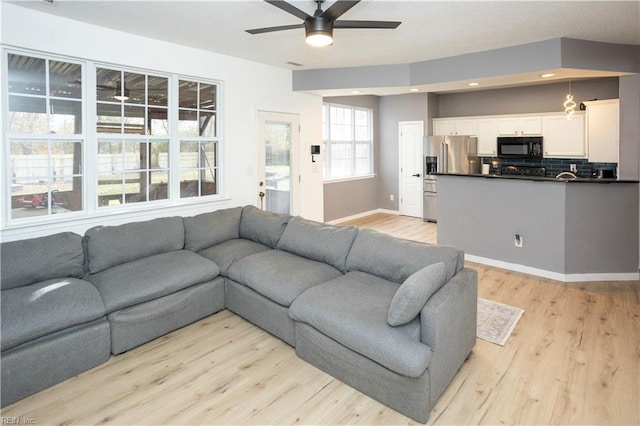 living room with light hardwood / wood-style flooring and ceiling fan