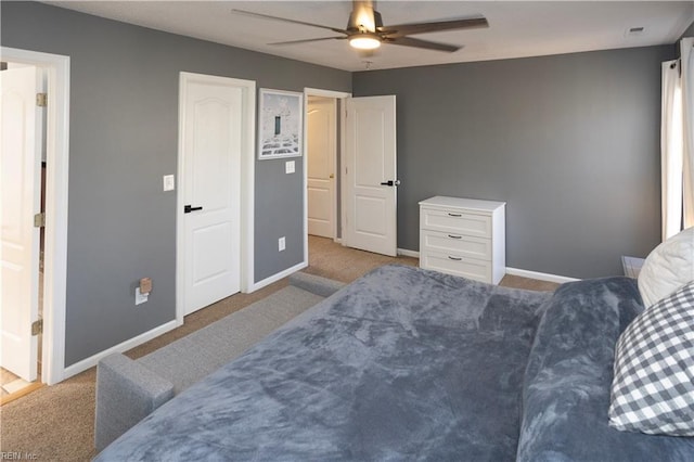 carpeted bedroom with ensuite bath and ceiling fan