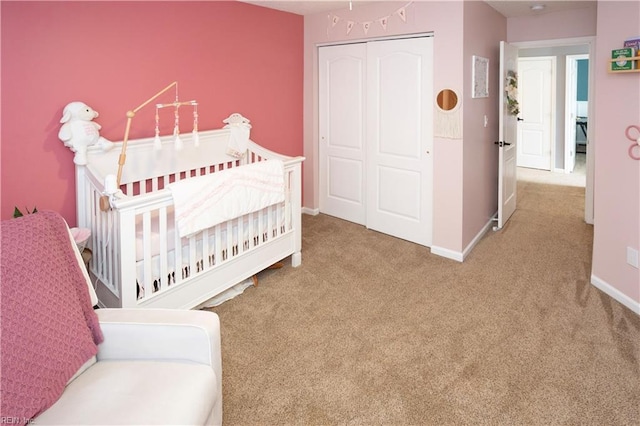 bedroom featuring a crib, carpet floors, and a closet