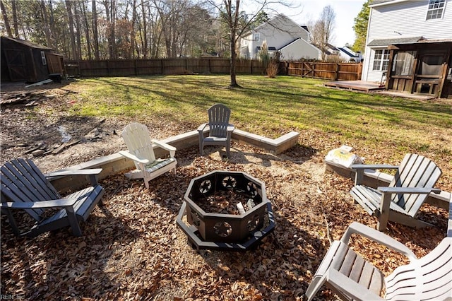 view of yard featuring a shed, a fire pit, and a deck