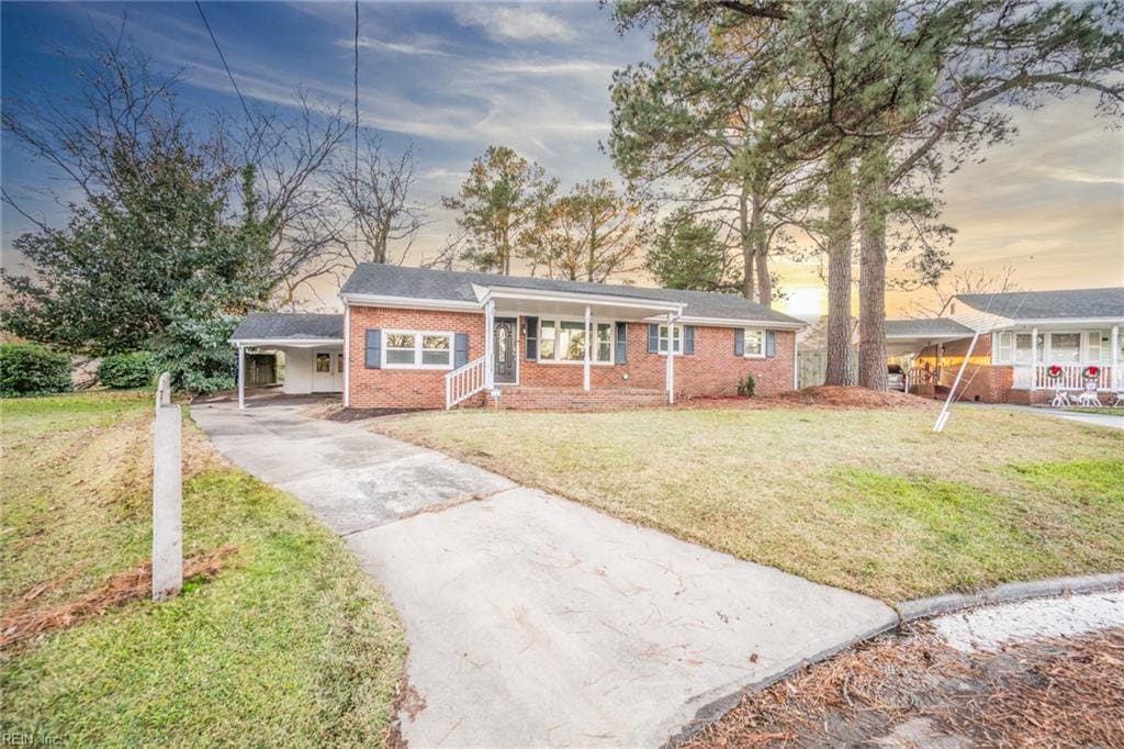 ranch-style house featuring a yard and a carport