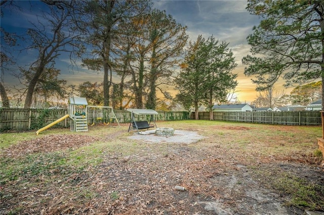 yard at dusk featuring a playground