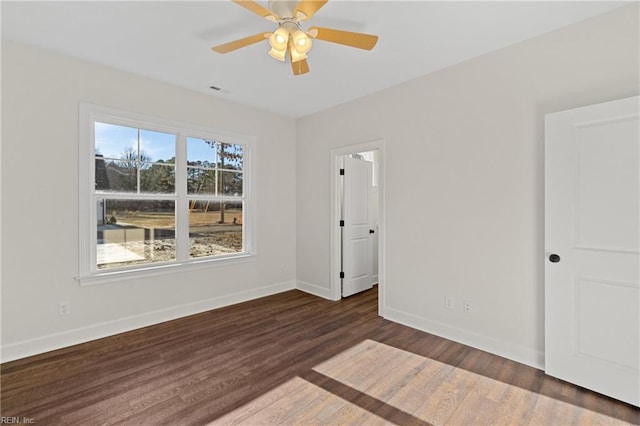 unfurnished room featuring ceiling fan and dark wood-type flooring