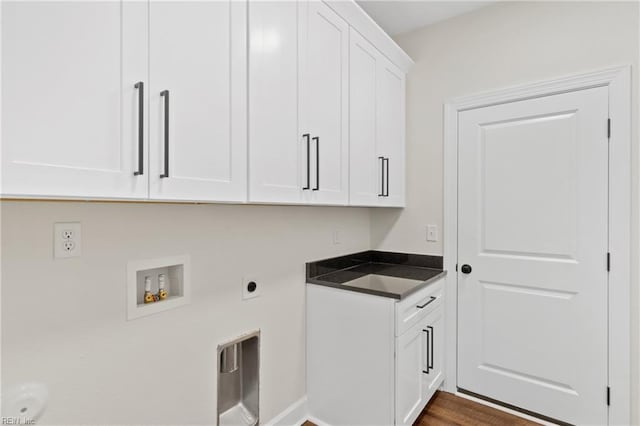 clothes washing area with electric dryer hookup, dark wood-type flooring, cabinets, and washer hookup