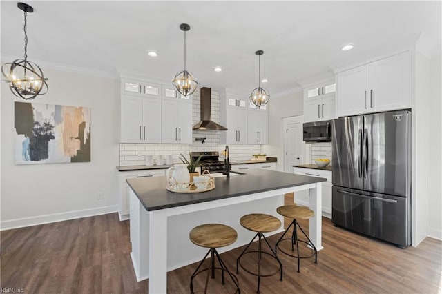 kitchen with white cabinets, appliances with stainless steel finishes, sink, and wall chimney range hood