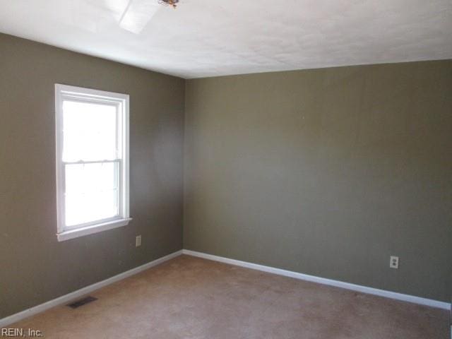 carpeted spare room with a healthy amount of sunlight