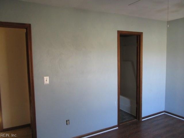 unfurnished bedroom with dark wood-type flooring and a closet