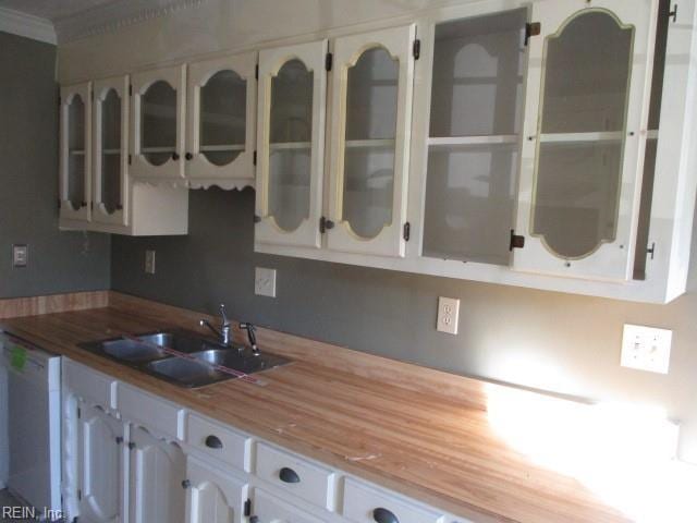 kitchen with sink, white cabinets, and white dishwasher