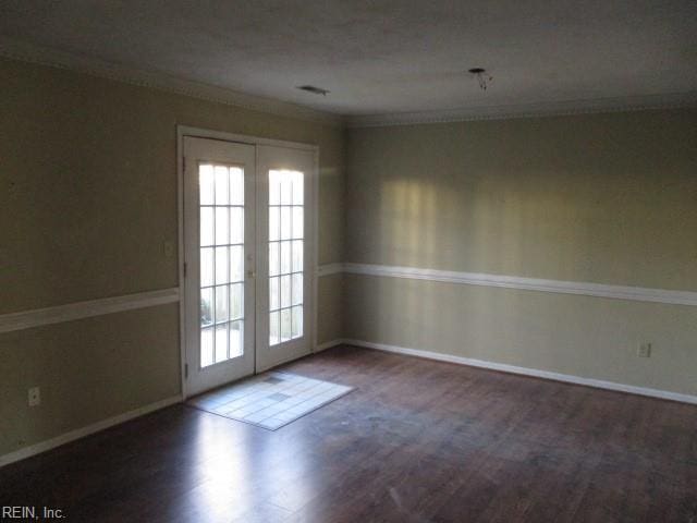 unfurnished room featuring crown molding, french doors, and dark wood-type flooring