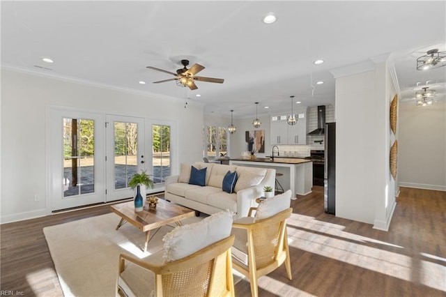 living room featuring dark hardwood / wood-style flooring, ceiling fan, sink, and ornamental molding