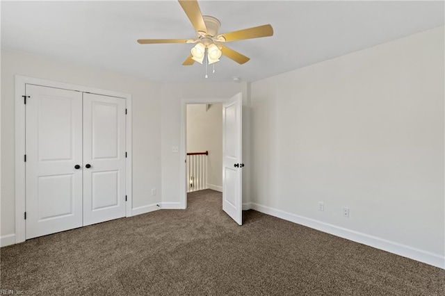 unfurnished bedroom with a closet, dark carpet, and ceiling fan