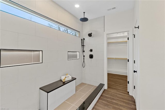 bathroom featuring wood-type flooring and tiled shower