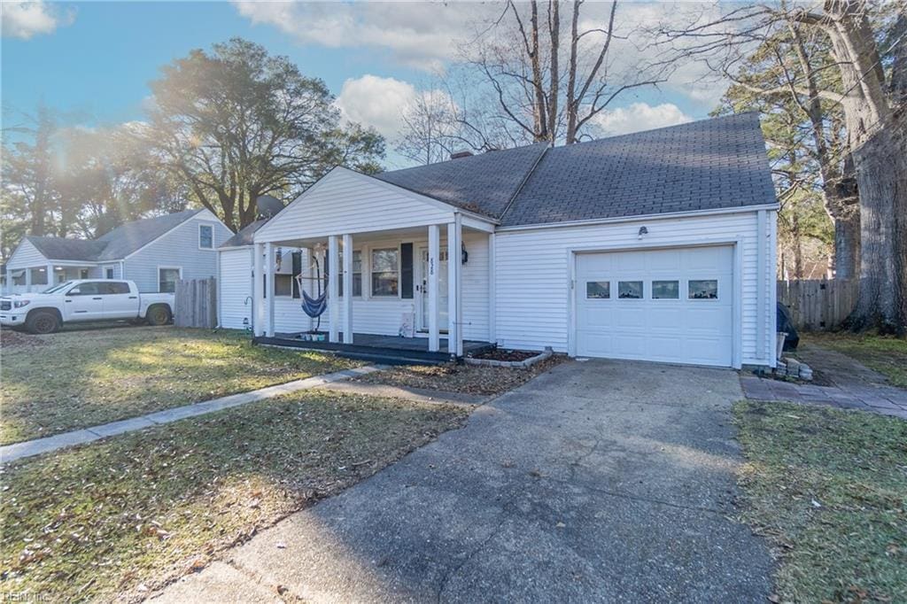 view of front of home with a porch, a garage, and a front lawn