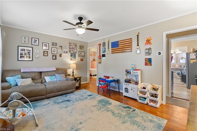 living room with hardwood / wood-style floors, ceiling fan, and crown molding