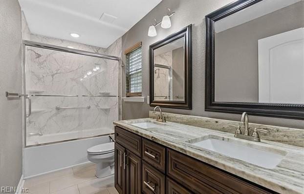 full bathroom featuring shower / bath combination with glass door, vanity, and toilet