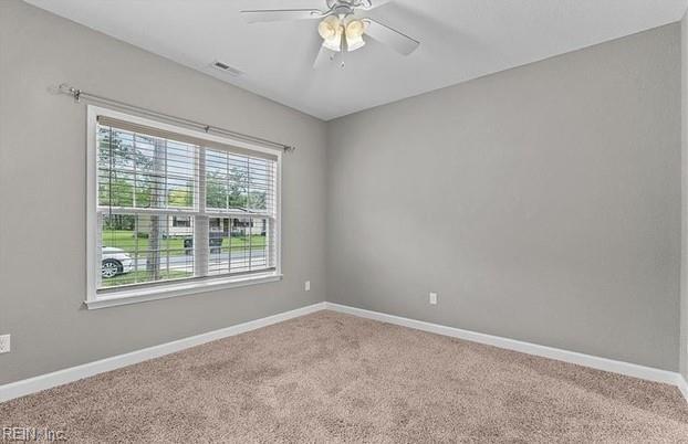 spare room with carpet and ceiling fan