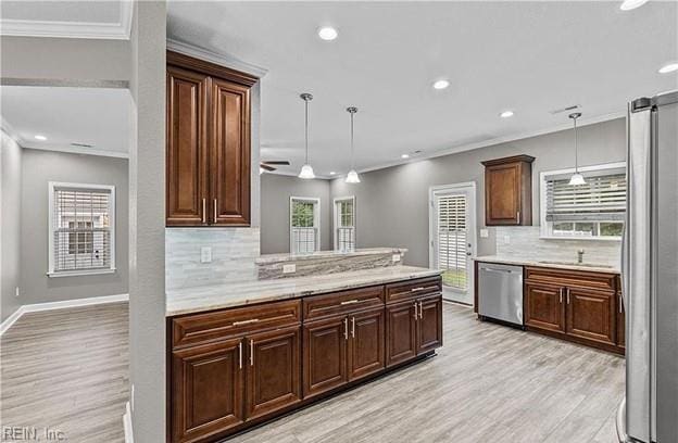 kitchen with kitchen peninsula, appliances with stainless steel finishes, tasteful backsplash, pendant lighting, and light hardwood / wood-style flooring