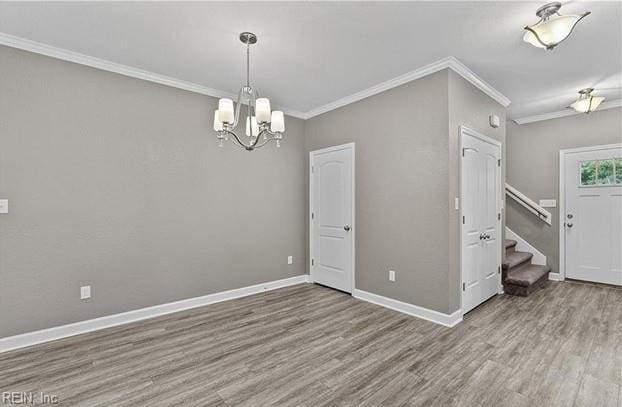 interior space with a chandelier, hardwood / wood-style flooring, and crown molding