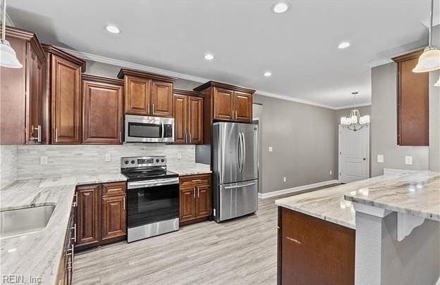 kitchen featuring appliances with stainless steel finishes, hanging light fixtures, and a notable chandelier