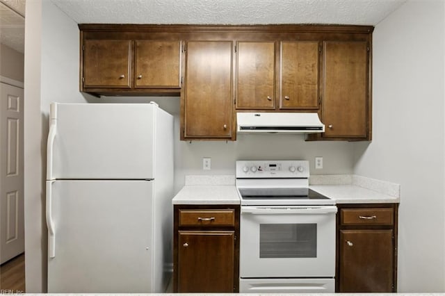 kitchen with white appliances and a textured ceiling