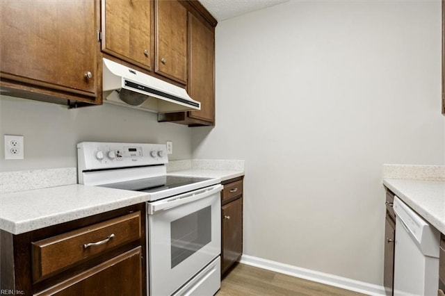 kitchen with white appliances and dark hardwood / wood-style floors