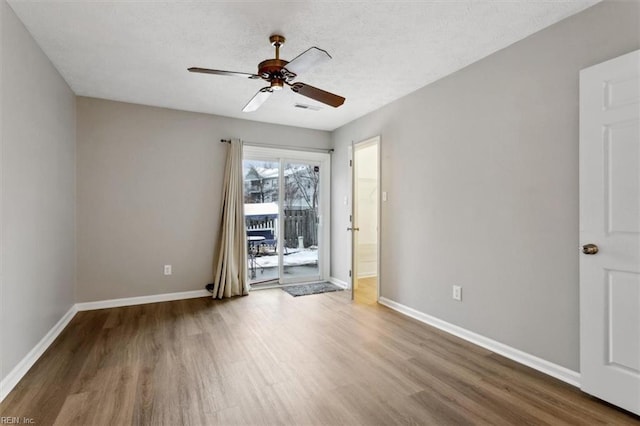 empty room featuring hardwood / wood-style floors, ceiling fan, and a textured ceiling