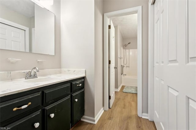 bathroom with vanity, hardwood / wood-style flooring, and shower / bathtub combination