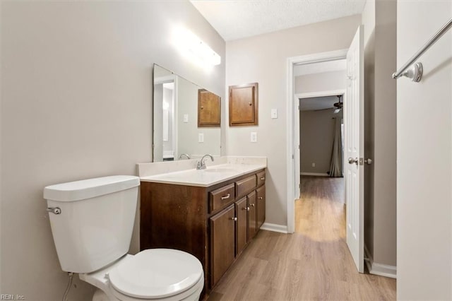 bathroom featuring ceiling fan, hardwood / wood-style floors, a textured ceiling, toilet, and vanity