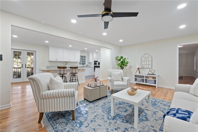 living room with french doors, light hardwood / wood-style flooring, and ceiling fan