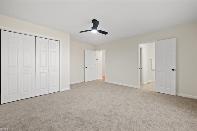 unfurnished bedroom featuring ceiling fan, a closet, and light colored carpet