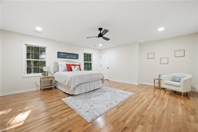 bedroom with multiple windows, ceiling fan, and light hardwood / wood-style floors