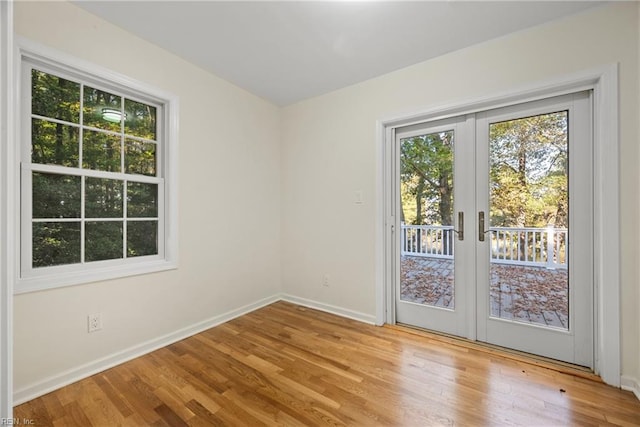 empty room with french doors and light hardwood / wood-style flooring