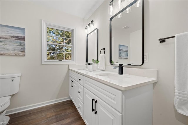 bathroom with hardwood / wood-style floors, vanity, and toilet