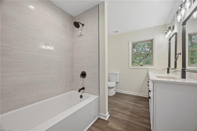 full bathroom with vanity, toilet, wood-type flooring, and tiled shower / bath