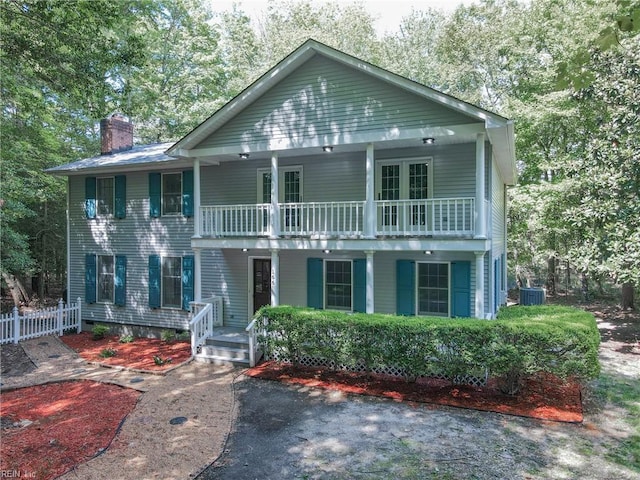 view of front of property with central air condition unit and a balcony