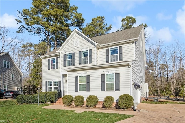 view of front of home with a front yard and a garage