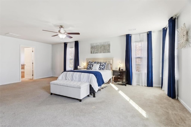 bedroom featuring connected bathroom, light colored carpet, and ceiling fan