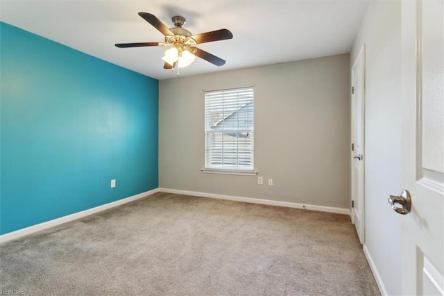 carpeted spare room featuring ceiling fan