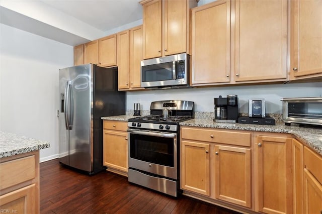 kitchen featuring dark hardwood / wood-style flooring, light stone counters, stainless steel appliances, and light brown cabinetry