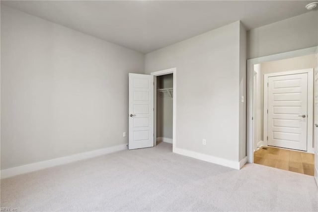 unfurnished bedroom with light carpet and a closet