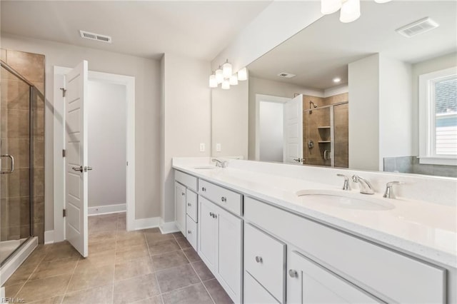 bathroom featuring tile patterned floors, vanity, and a shower with shower door