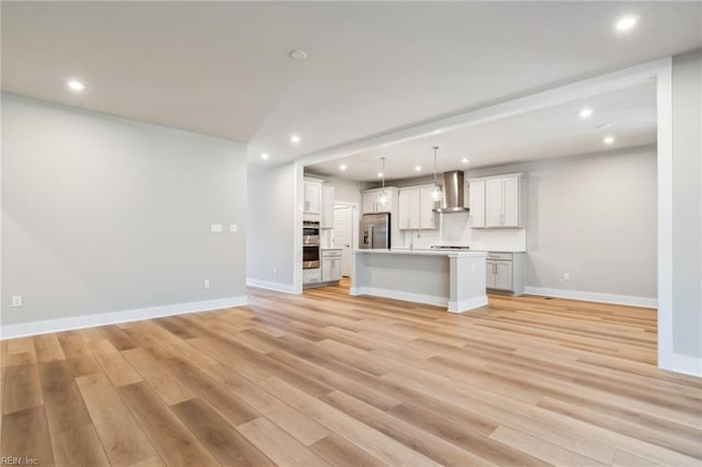 unfurnished living room featuring sink and light wood-type flooring