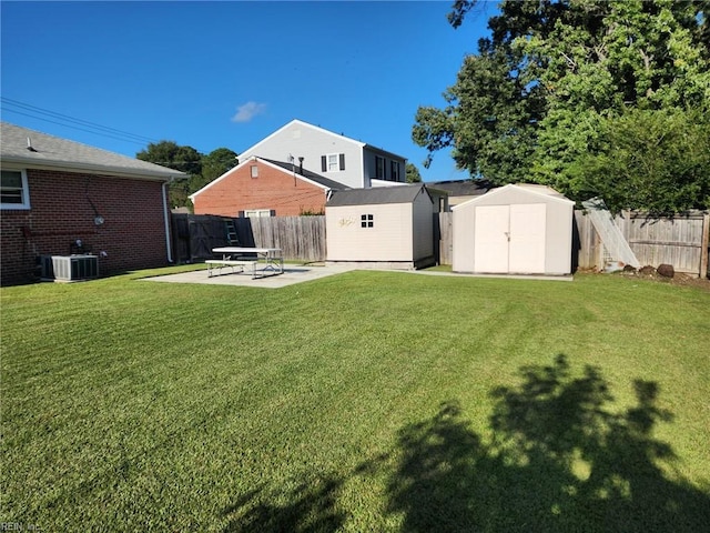 rear view of property featuring a patio area, a yard, a shed, and central AC