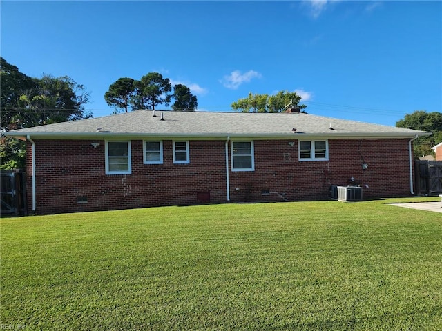 back of house featuring a yard and central AC