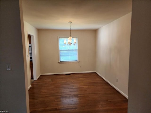 unfurnished dining area featuring dark hardwood / wood-style floors and a notable chandelier