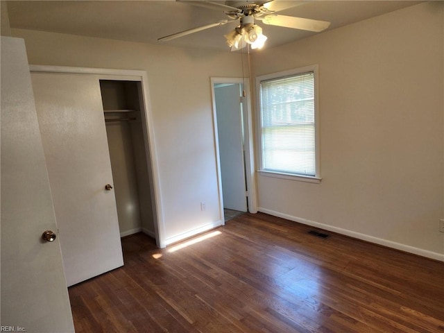 unfurnished bedroom with a closet, dark hardwood / wood-style floors, and ceiling fan