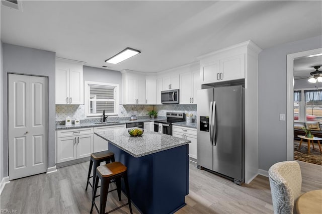 kitchen featuring a center island, sink, white cabinetry, and stainless steel appliances