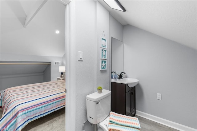 bathroom featuring vanity, toilet, lofted ceiling, and wood-type flooring