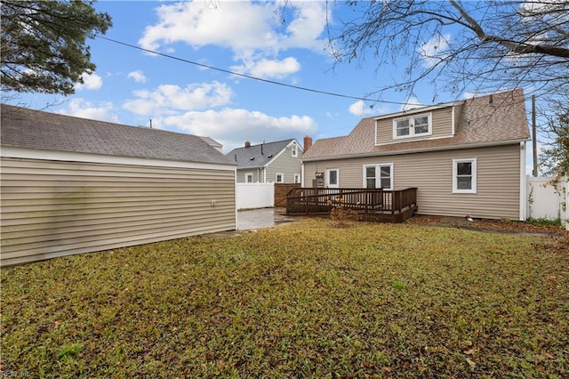 back of property featuring a deck and a yard